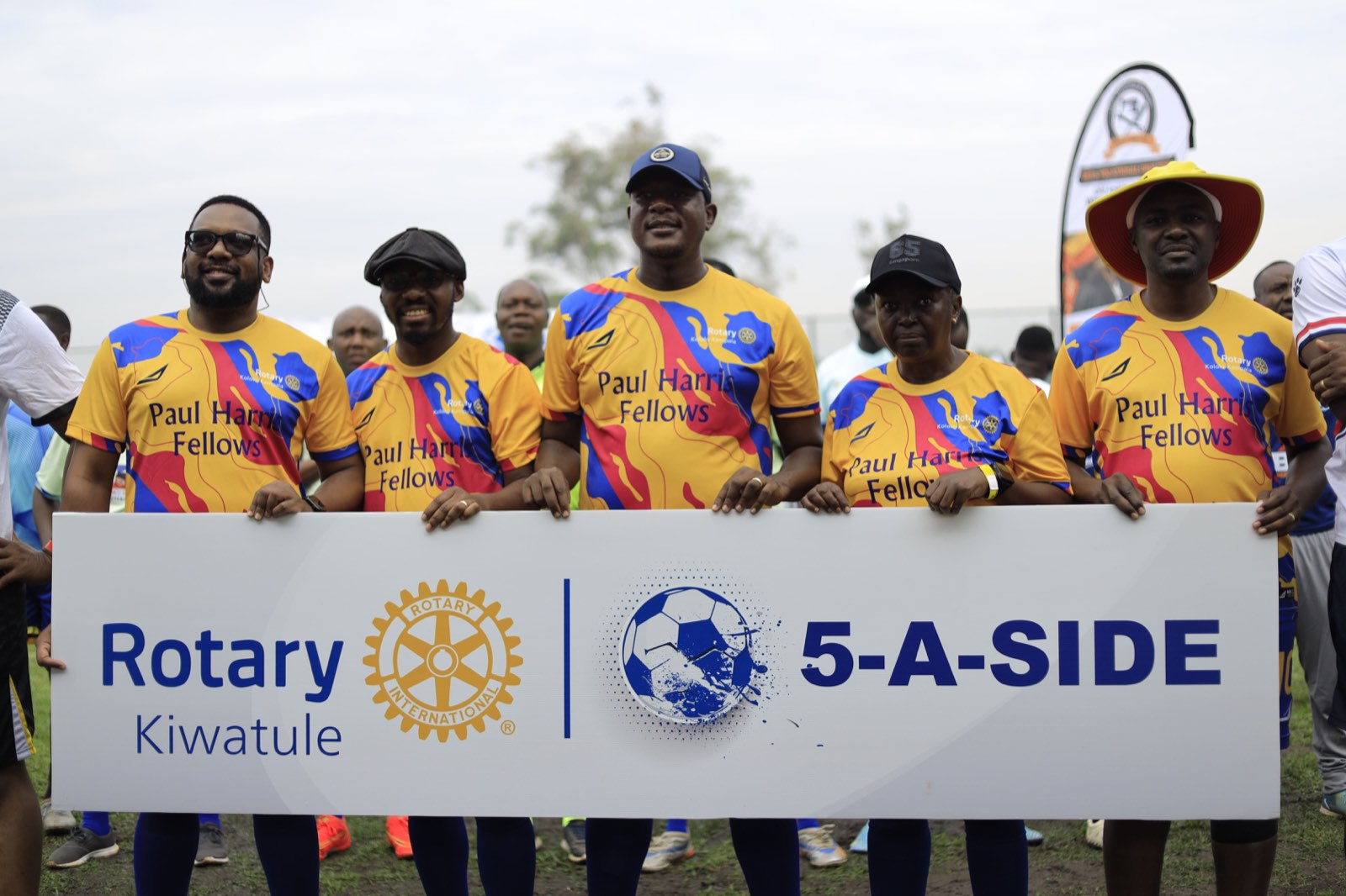 Rotarians holding the Rotary Kiwatule 5-A-Side banner